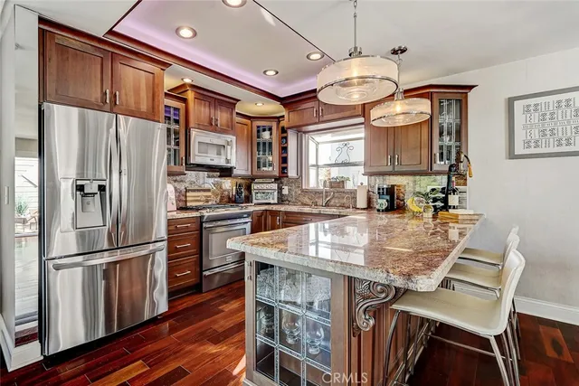 a kitchen with stainless steel appliances granite countertop a sink a stove and a refrigerator