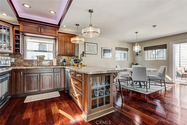 a kitchen with stainless steel appliances granite countertop a stove and a wooden floors