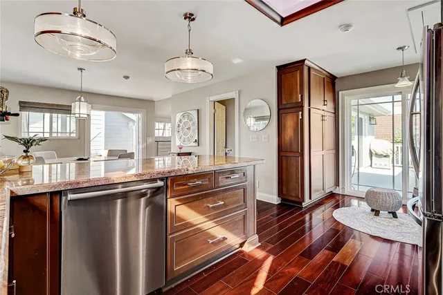 a kitchen with stainless steel appliances a large counter space wooden floor and window