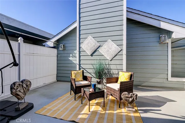 a patio with table and chairs and potted plants
