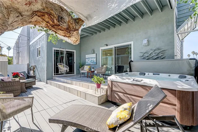 a view of the patio with couches and table and chairs with wooden fence and plants