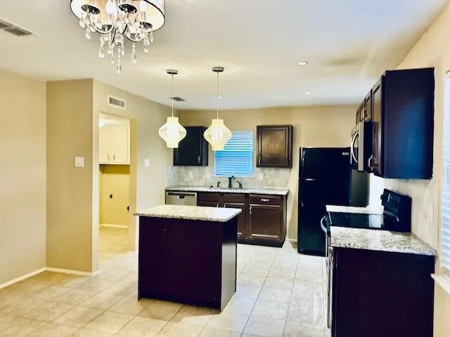 a kitchen with stainless steel appliances granite countertop a sink counter space cabinets and a refrigerator