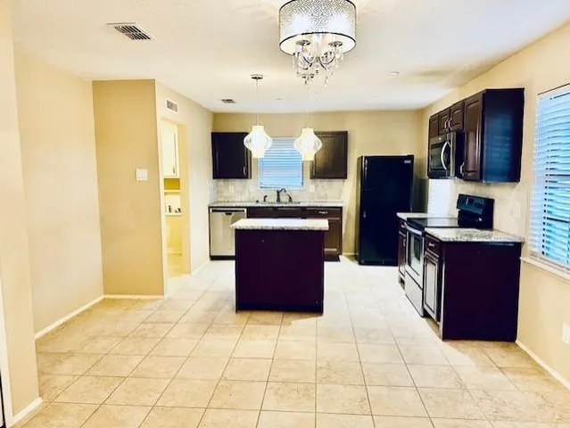 a kitchen with stainless steel appliances granite countertop a stove refrigerator and microwave