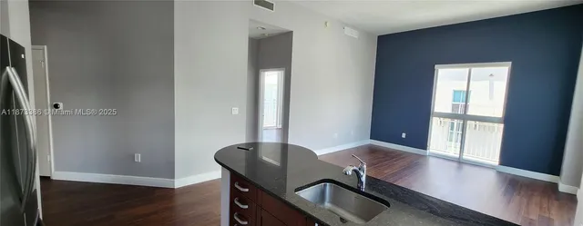 a view of a workspace room with wooden floor and windows