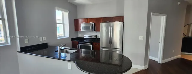 a kitchen with a refrigerator sink and cabinets