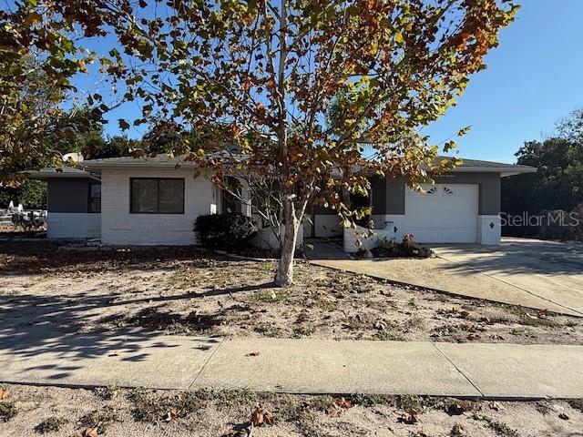6913 Pinehurst Drive Spring Hill, FL 34606 - Photo 1 of 1 a house with trees in the background