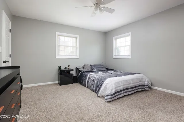 a bed room with a bed and a ceiling fan