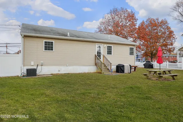 a view of backyard with swimming pool and seating space