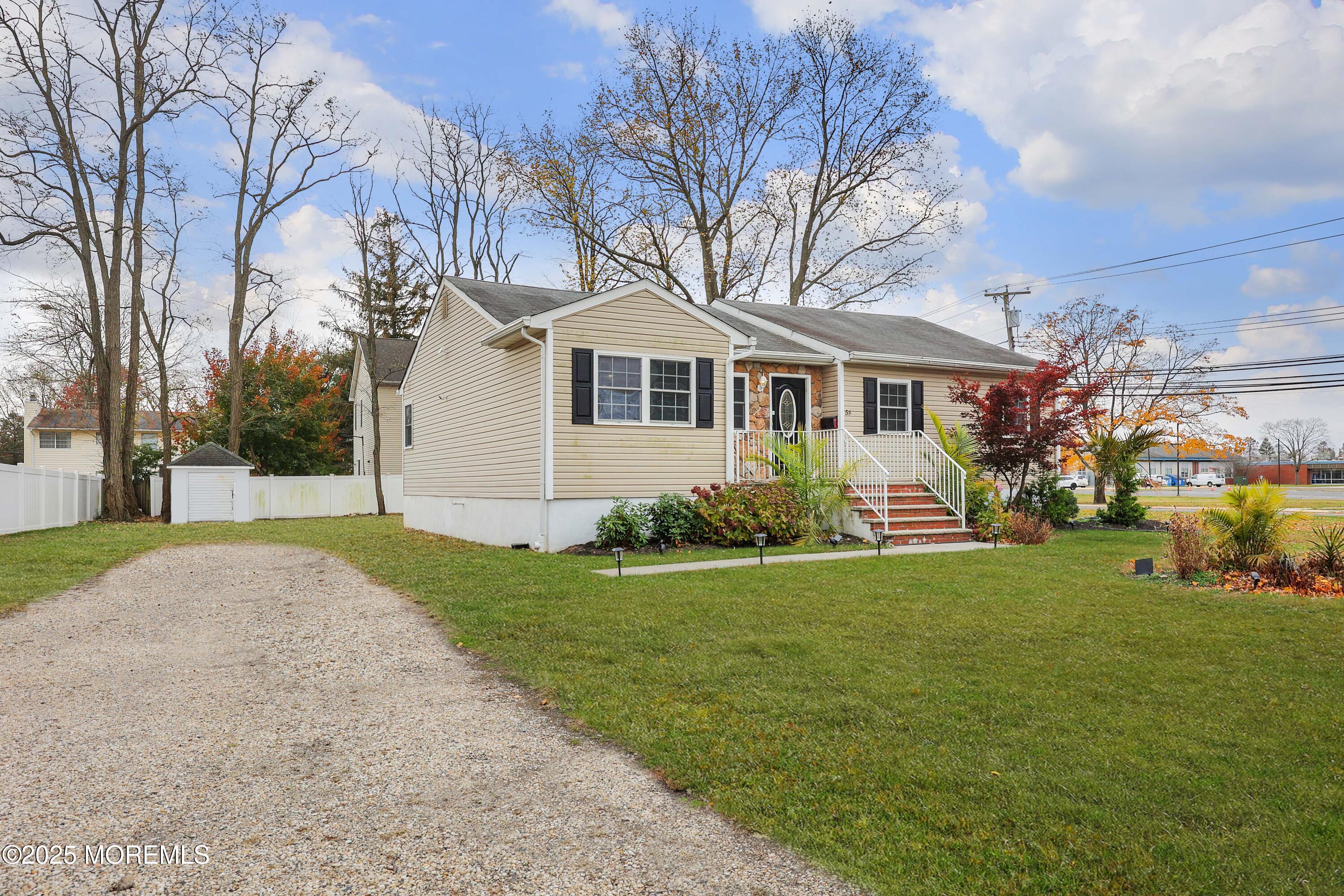 58 Richardson Avenue Eatontown, NJ 07724 - Photo 5 of 26 a front view of a house with a garden and trees
