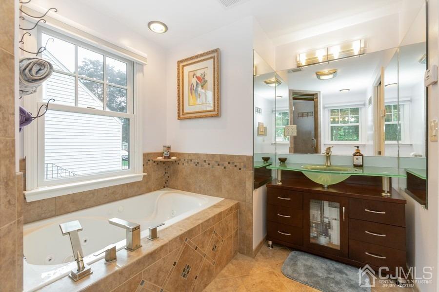 817 Dunellen Avenue Dunellen, NJ 08812 - Photo 13 of 20 a spacious bathroom with a granite countertop tub sink a mirror and a shower