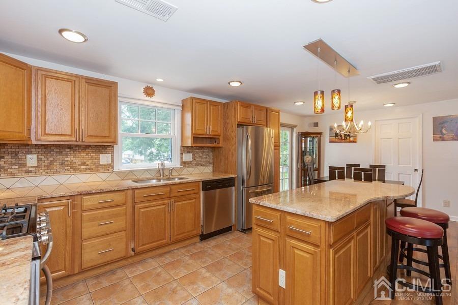 817 Dunellen Avenue Dunellen, NJ 08812 - Photo 10 of 20 a large kitchen with stainless steel appliances granite countertop a sink a stove a dining table and chairs