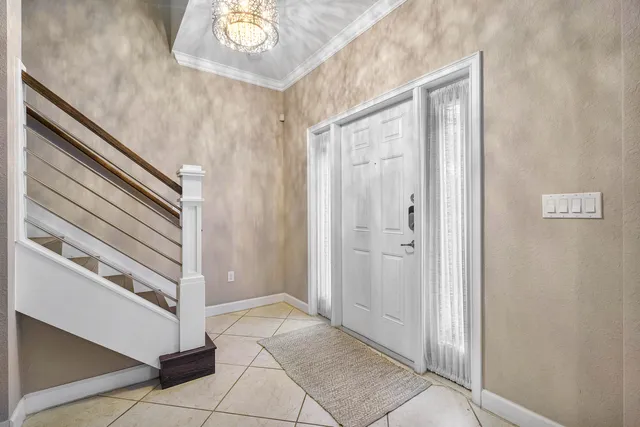 a view of a hallway with entryway and chandelier