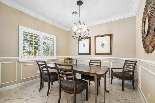 a bed sitting in a bedroom next to a window and a chandelier