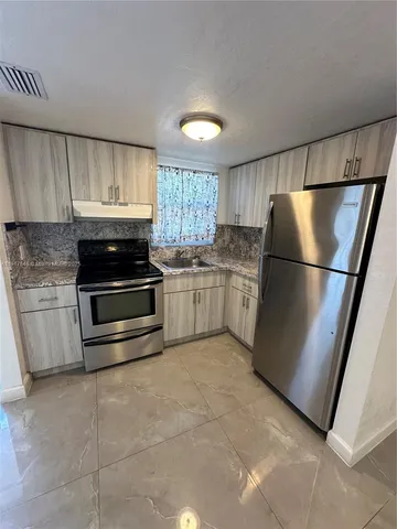 a kitchen with stainless steel appliances granite countertop a refrigerator sink and cabinets