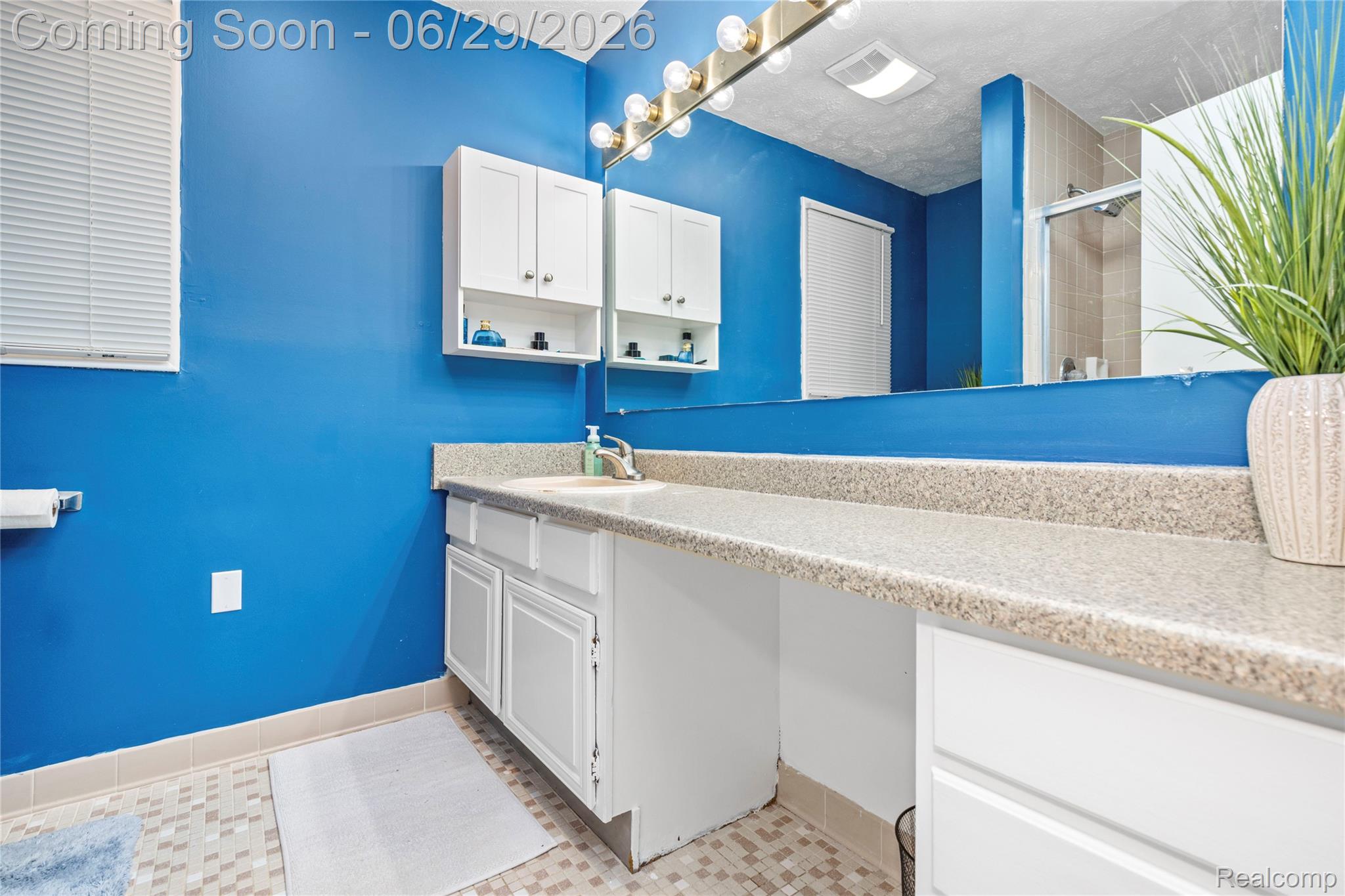 6085 Worlington Road Bloomfield Hills, MI 48301 - Photo 39 of 75 Vanity area featuring a spacious countertop, white cabinetry with storage, large mirror, and overhead vanity lighting