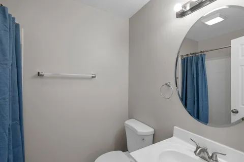 a white toilet sitting next to a shower curtain