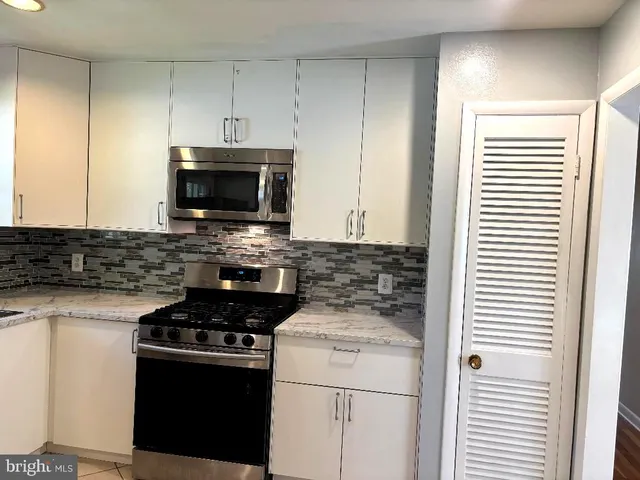 a kitchen with microwave cabinets and stove top oven