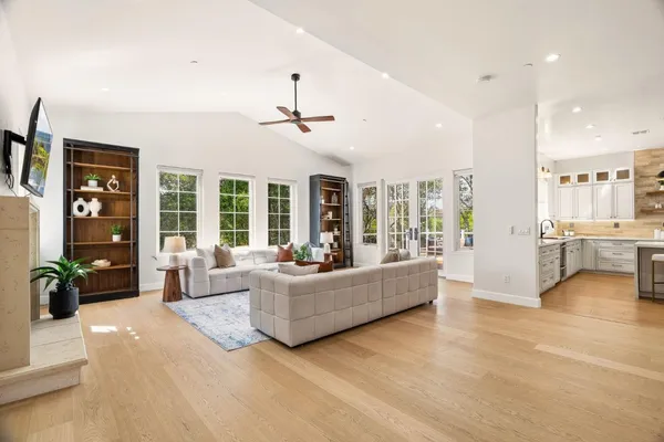 a kitchen with stainless steel appliances kitchen island granite countertop a refrigerator a sink and white cabinets