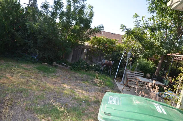 a view of a backyard with plants and outdoor seating
