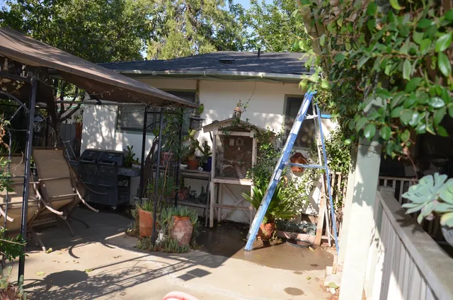 a view of a building with sitting area and garden