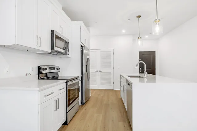 a kitchen with stainless steel appliances granite countertop a sink stove and refrigerator