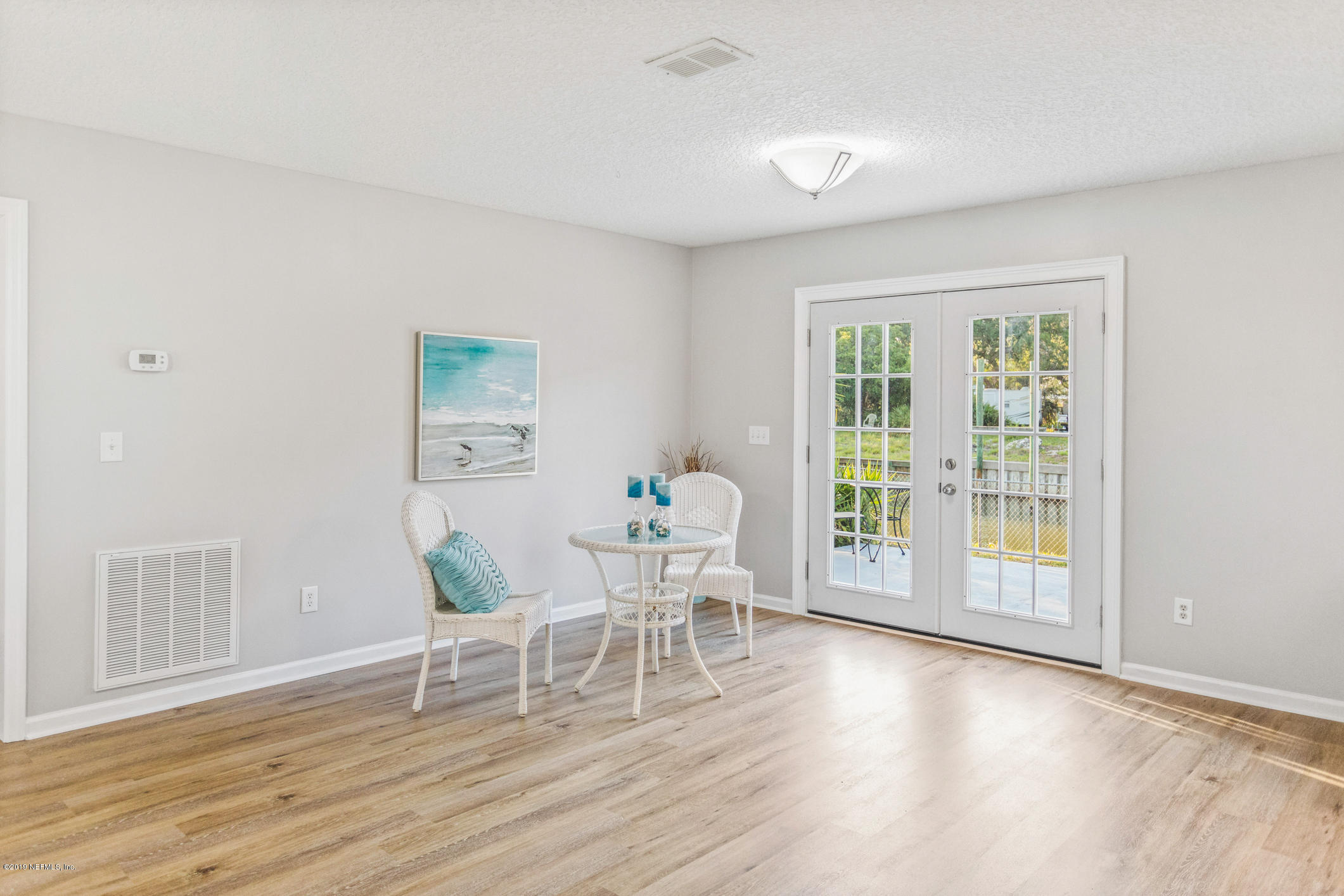 242 Puebla Road St. Augustine, FL 32080 - Photo 13 of 48 a dining room with wooden floor and a floor to ceiling window