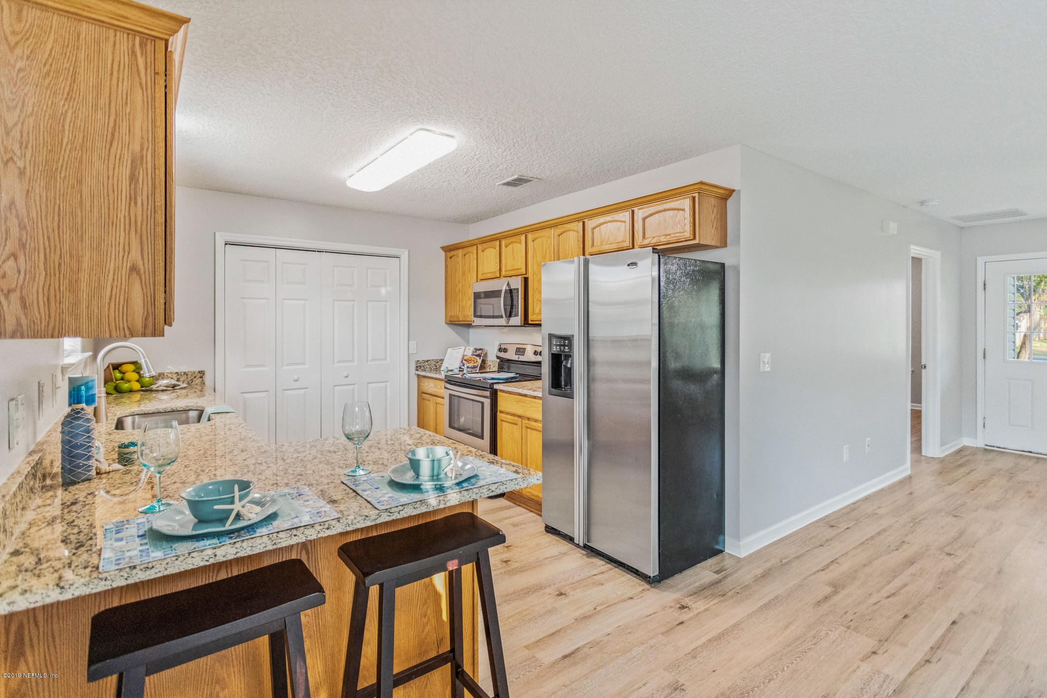 242 Puebla Road St. Augustine, FL 32080 - Photo 15 of 48 a kitchen with stainless steel appliances granite countertop a refrigerator a stove and a wooden floors
