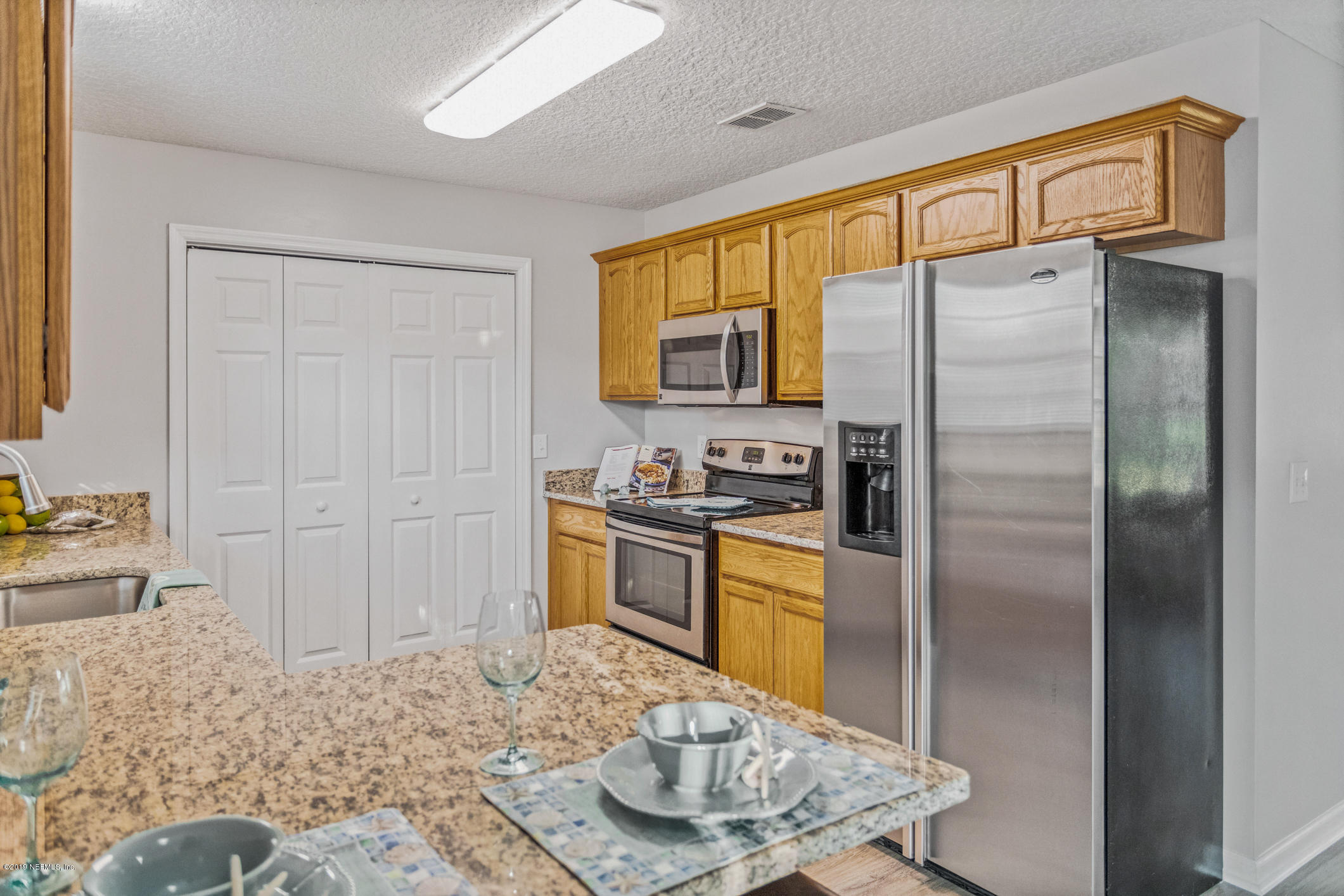 242 Puebla Road St. Augustine, FL 32080 - Photo 17 of 48 a kitchen with stainless steel appliances granite countertop a refrigerator a stove and a sink with granite countertops