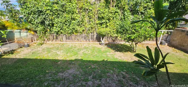 a view of a yard with wooden fence