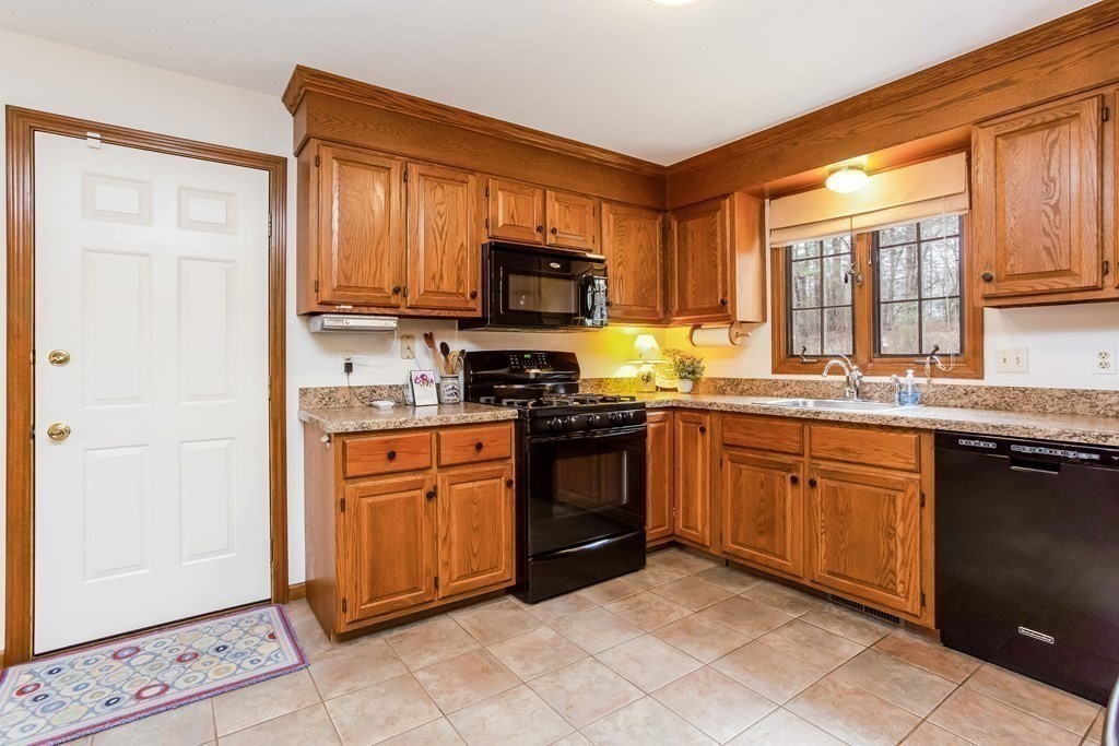 218 Somers Road Hampden, MA 01036 - Photo 9 of 32 a kitchen with stainless steel appliances granite countertop wooden cabinets a stove a sink and a window