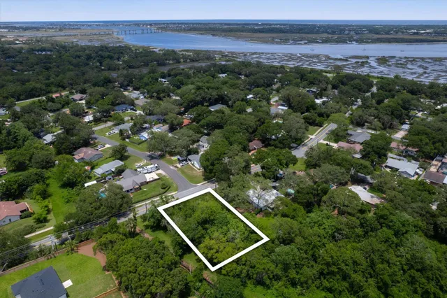 an aerial view of residential houses with outdoor space and trees