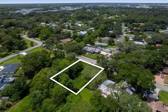 an aerial view of residential house with outdoor space and trees all around