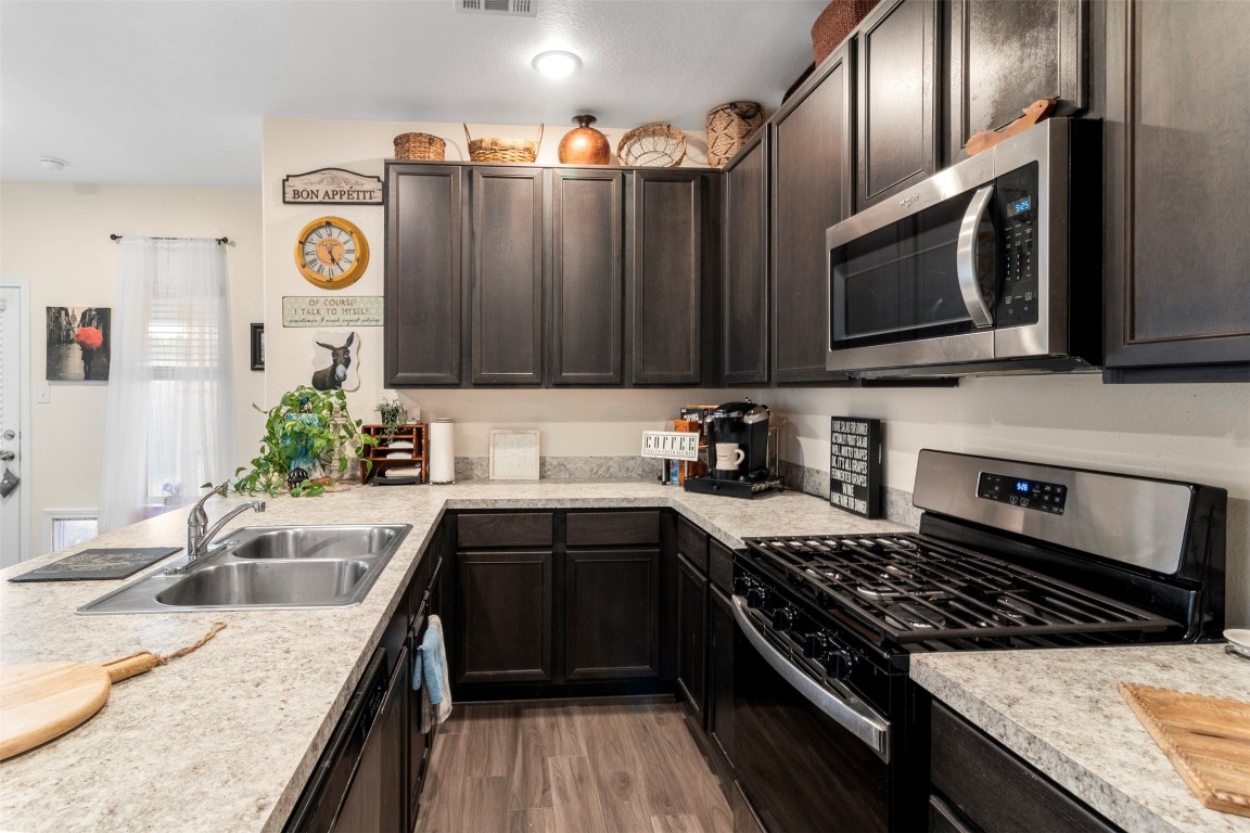 22565 Cormorant Court Splendora, TX 77372 - Photo 11 of 31 a kitchen with stainless steel appliances granite countertop a sink stove and microwave