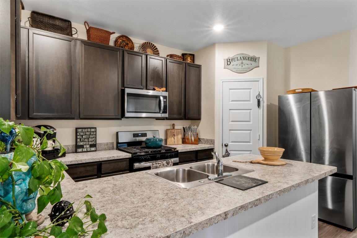 22565 Cormorant Court Splendora, TX 77372 - Photo 12 of 31 a kitchen with stainless steel appliances granite countertop a refrigerator and a stove top oven