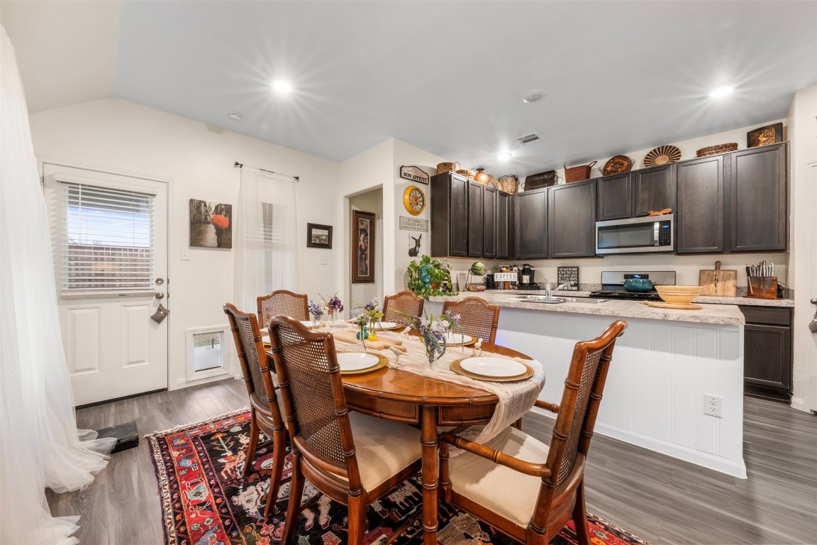 22565 Cormorant Court Splendora, TX 77372 - Photo 17 of 31 a dining room with stainless steel appliances kitchen island granite countertop a dining table and chairs