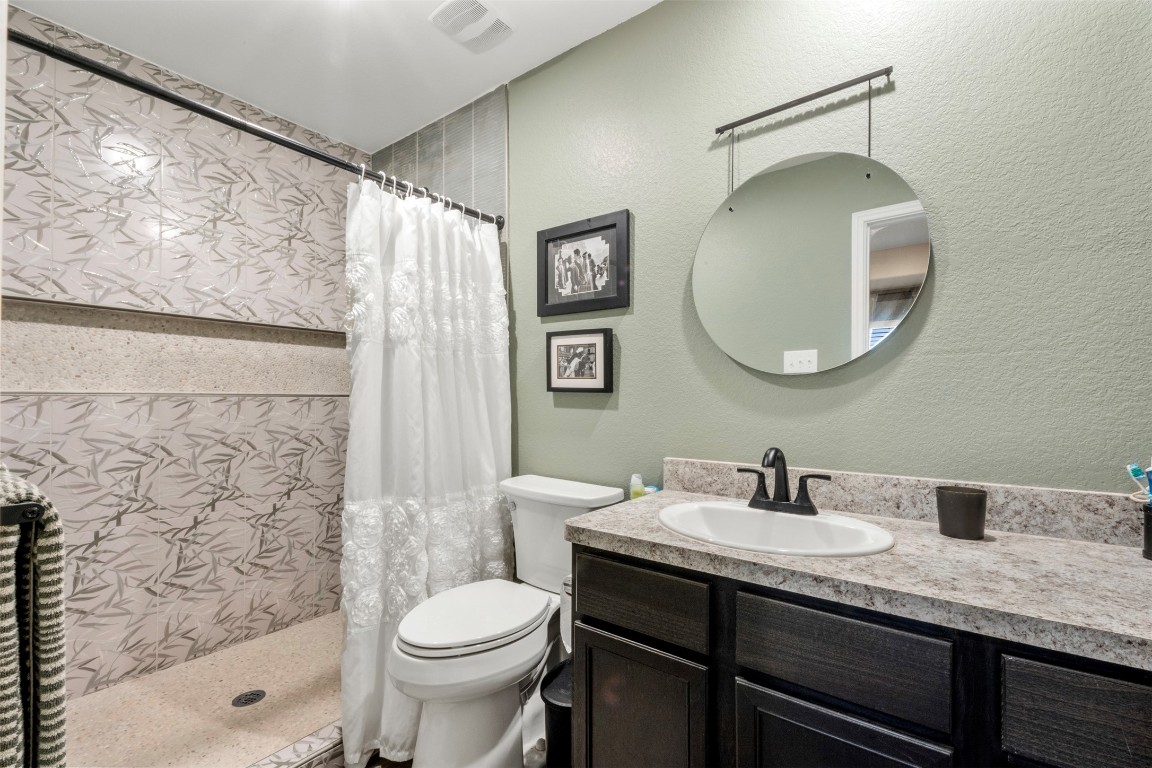 22565 Cormorant Court Splendora, TX 77372 - Photo 20 of 31 a bathroom with a granite countertop sink toilet and shower