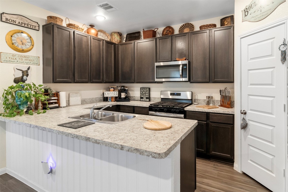 22565 Cormorant Court Splendora, TX 77372 - Photo 10 of 31 a kitchen with stainless steel appliances granite countertop a sink stove and refrigerator