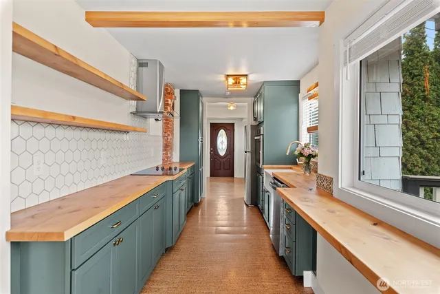 a large kitchen with stainless steel appliances a large counter top