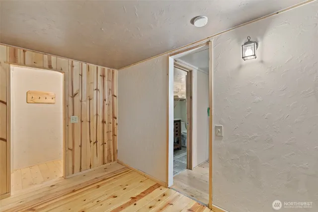 a view of a hallway with wooden floor and cabinet