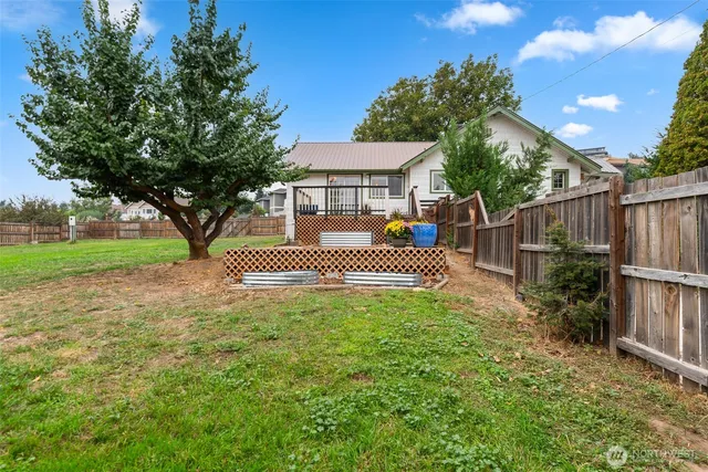 a view of a house with a small yard and wooden fence