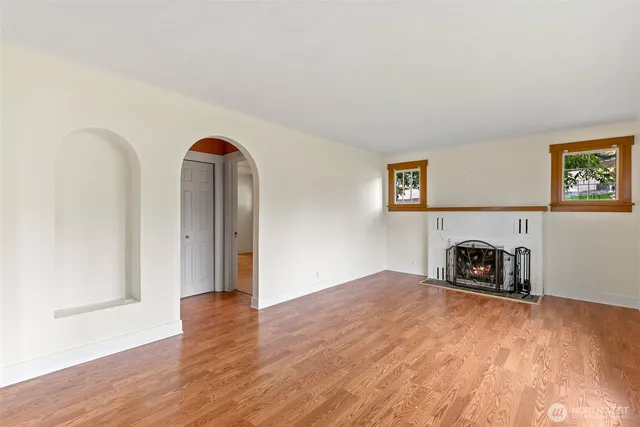 a view of a livingroom with wooden floor and a fireplace