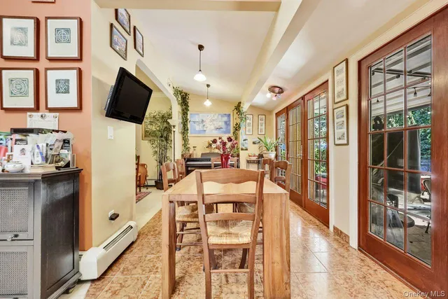a living room with stainless steel appliances furniture a fireplace and a flat screen tv