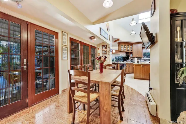 a dining area with stainless steel appliances kitchen island granite countertop a table and chairs