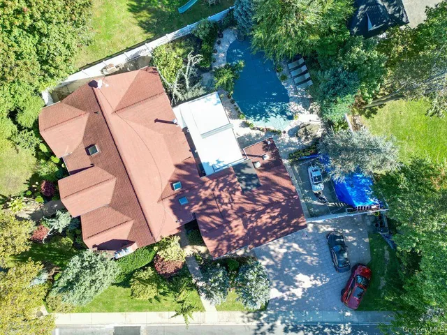 an aerial view of a house with a yard and a large tree
