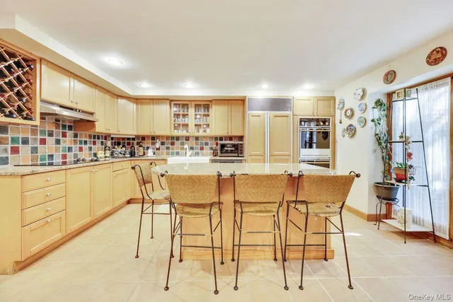 a kitchen with stainless steel appliances kitchen island granite countertop a table and chairs