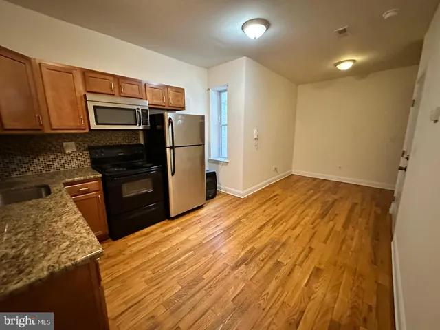 a kitchen with granite countertop stainless steel appliances and wooden cabinets
