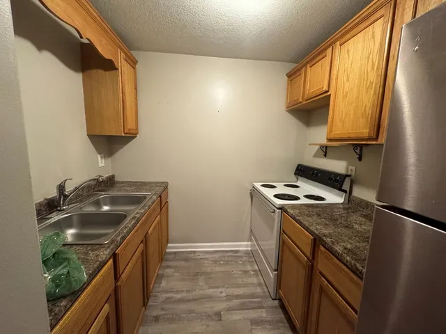 a kitchen with a sink stove top oven and cabinets