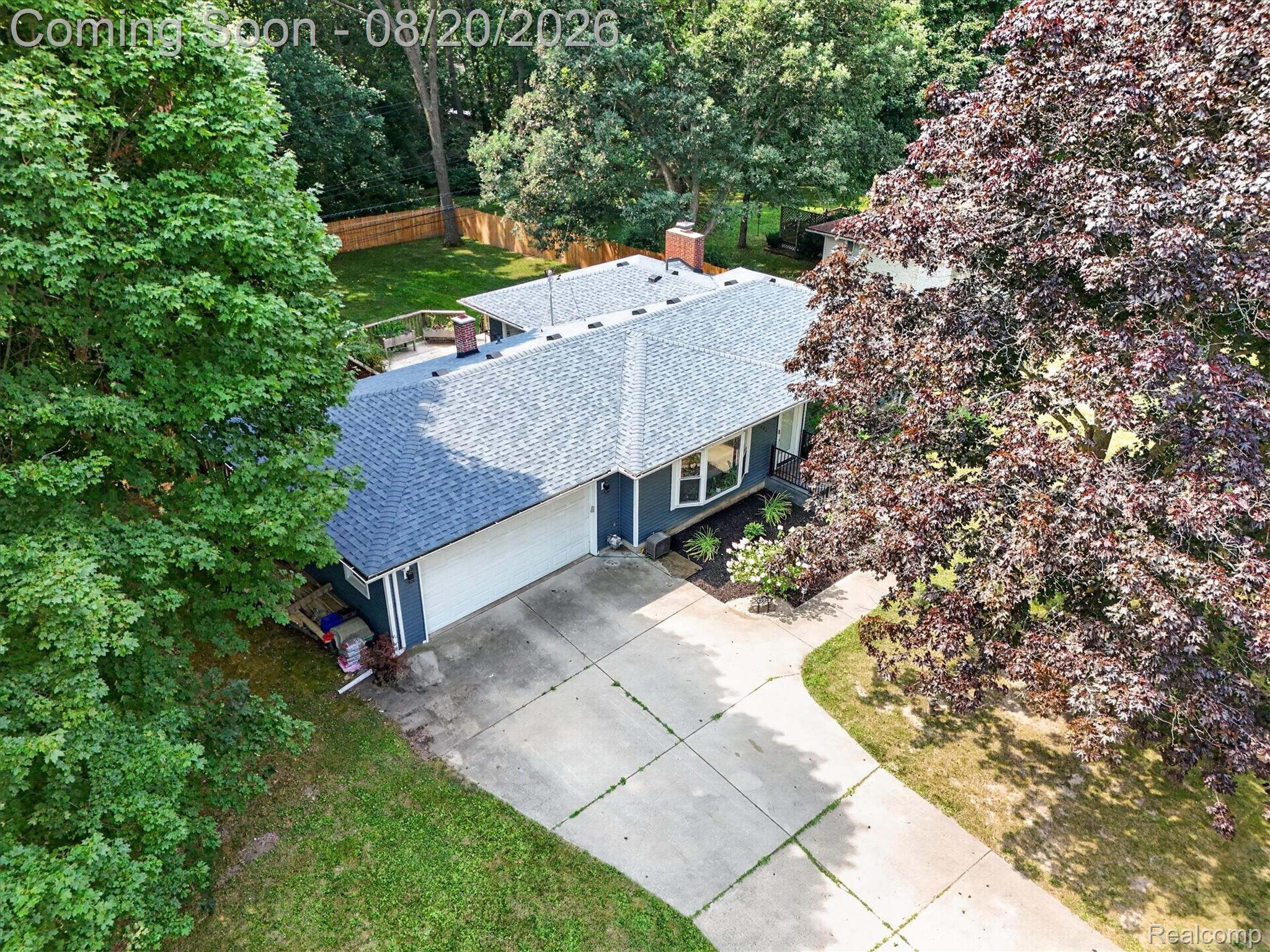 6235 Waldon Road Clarkston, MI 48346 - Photo 33 of 41 Exterior featuring a dark blue siding, light gray shingle roof, attached garage, and a concrete driveway