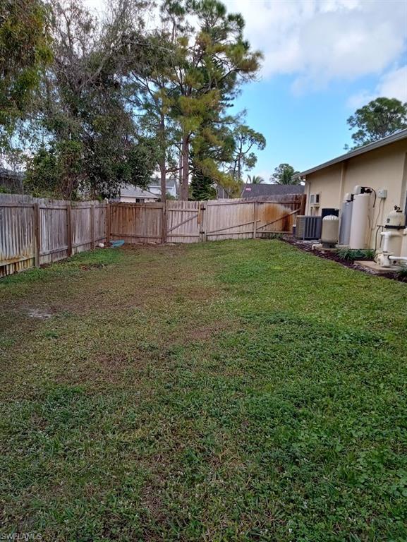 9148 Henry Road Fort Myers, FL 33967 - Photo 29 of 34 a view of backyard with wooden fence and large trees