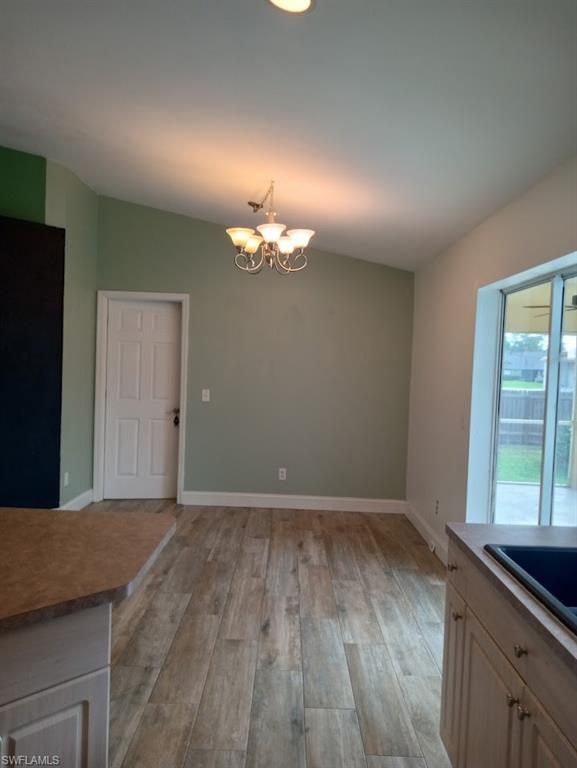 9148 Henry Road Fort Myers, FL 33967 - Photo 8 of 34 wooden floor in an empty room with a window